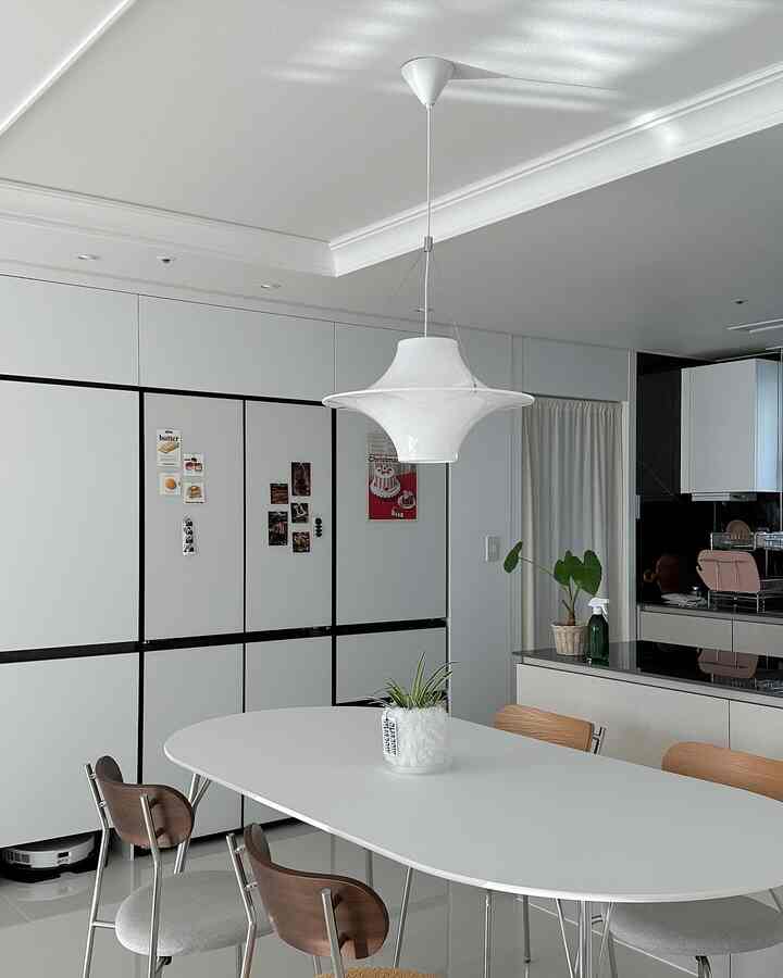 White and brown toned dining room featuring a modern oval table and chairs with a cozy atmosphere