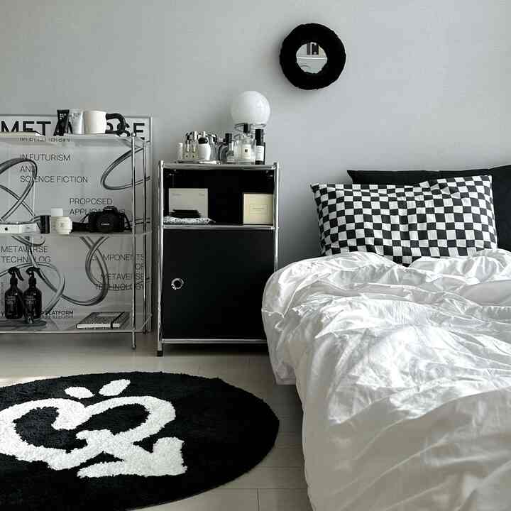 Modern bedroom in black and white tones featuring checkered pillows and sleek shelves with a stylish atmosphere