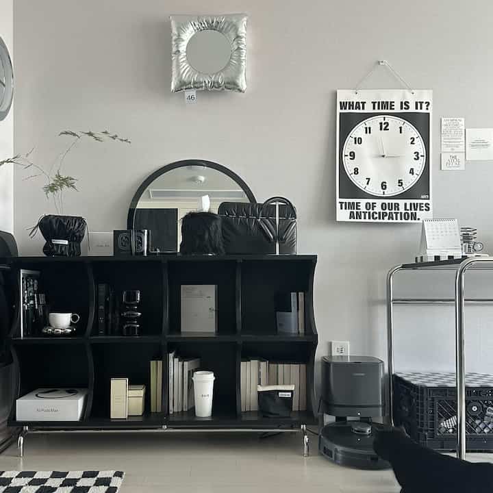 Mid-century modern home office with black furniture against white walls, decorated with sleek accessories