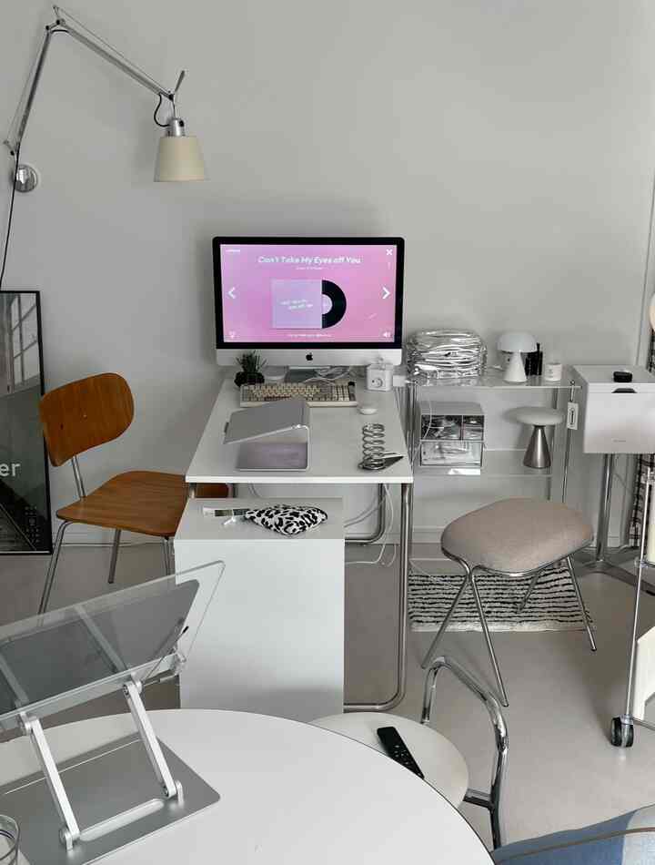 白と木目調のモダンなホームオフィス空間に、コンピュータデスクとスタンドライト、オフィスチェアが配置された整理された作業室