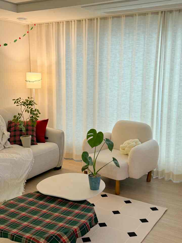 ベージュとホワイトのリビングルーム、ソファやアームチェア、コーヒーテーブル、植物が配置された雰囲気のあるモダンな空間