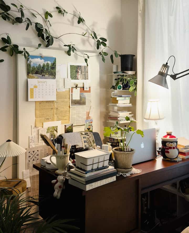 Warm wood tone home office workspace featuring a laptop, plants, and cozy lighting creating a comfortable atmosphere