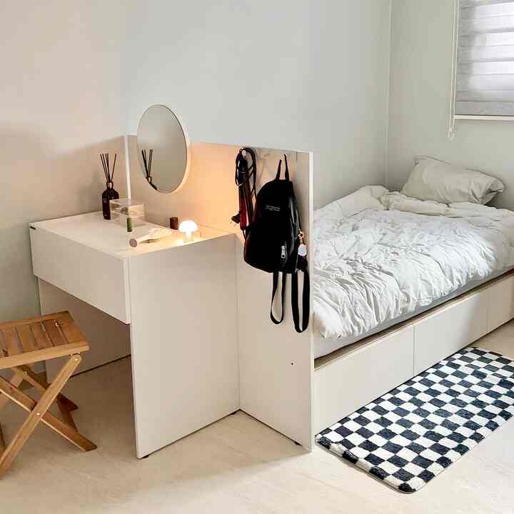 White-toned bedroom space featuring a storage bed and modular vanity, creating a neat and compact atmosphere