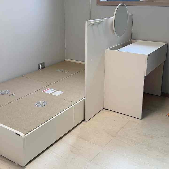 White and natural toned compact kids' room featuring a storage bed frame and modular vanity in a clean setting