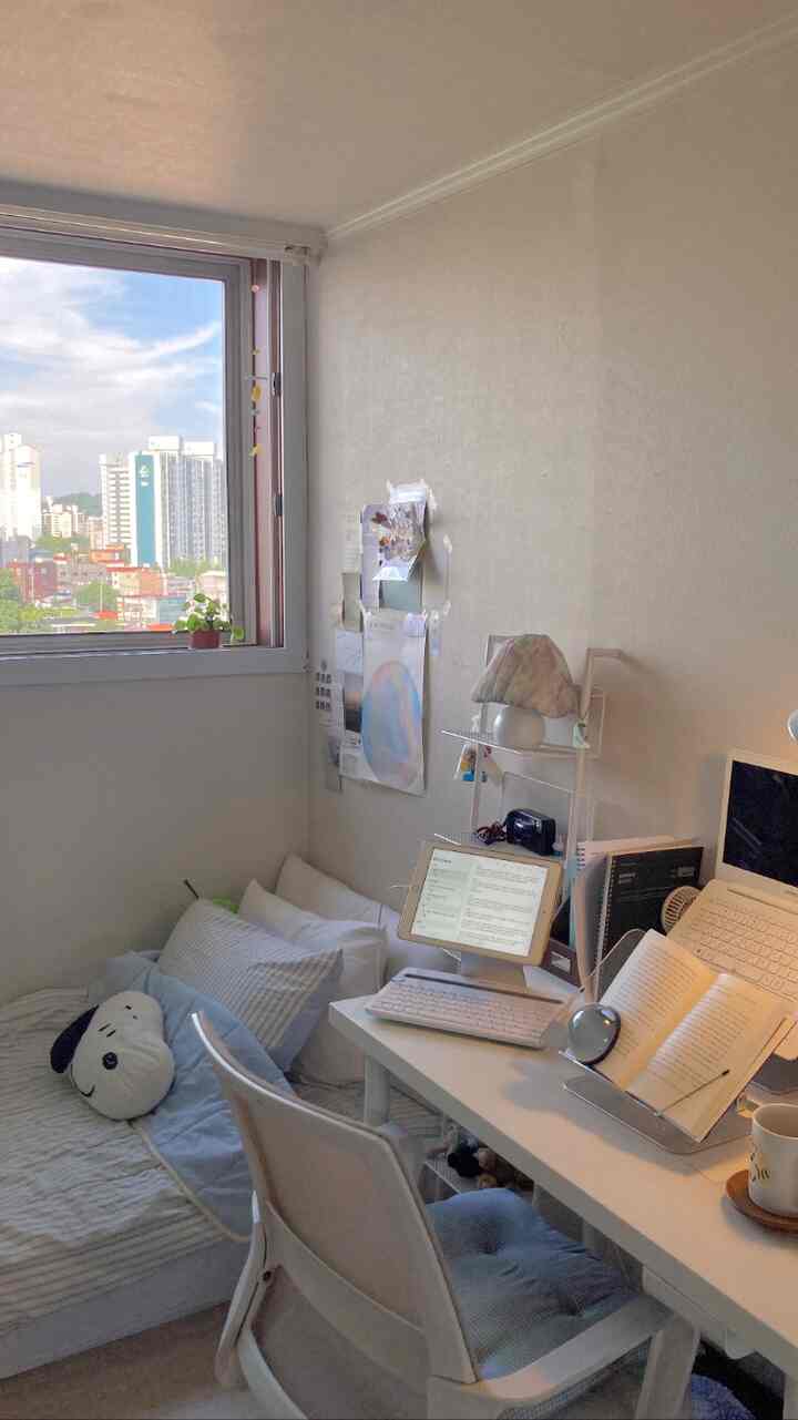 白と木目調の小さな1K寝室兼ホームオフィス、デスクとシングルベッドが配置されたシンプルモダンな空間