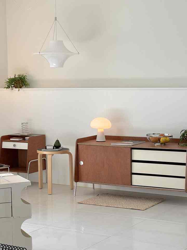 White and wood-tone dining room featuring a simple modern sideboard and stool in a cozy atmosphere