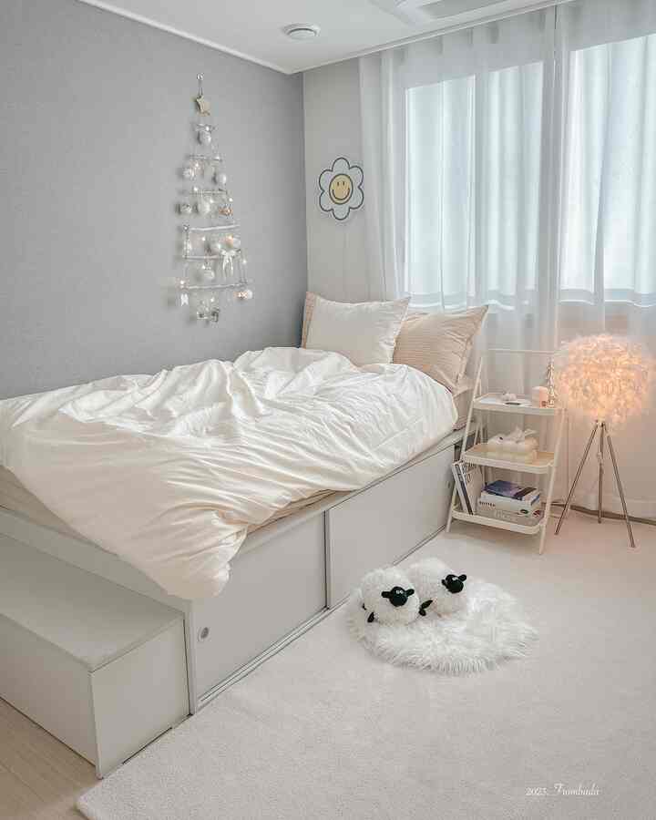 明るいホワイトトーンの子供部屋、ホワイトベッドと掛け布団カバー、可愛い羊のぬいぐるみと温かみのある照明が配置された雰囲気のあるインテリア