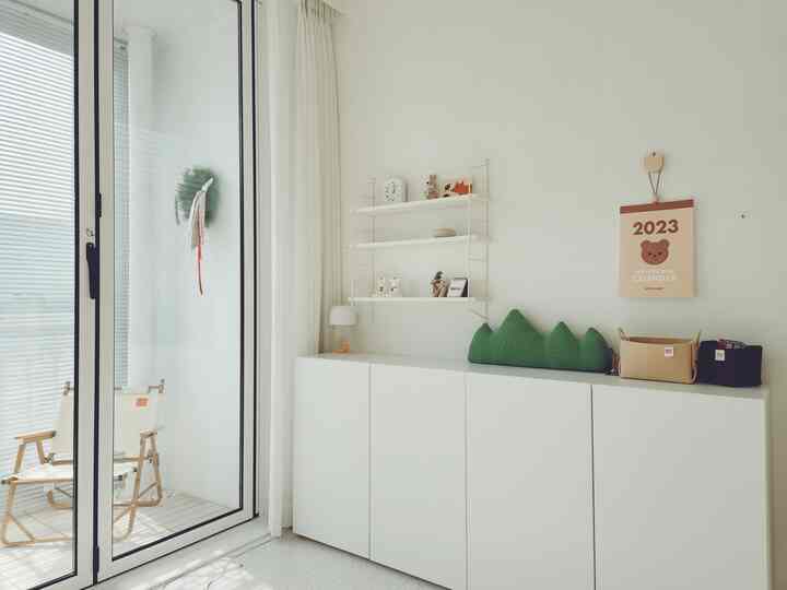 明るい白を基調とした子供部屋、扉付き収納棚が配置されたナチュラルでモダンな雰囲気のあるインテリア