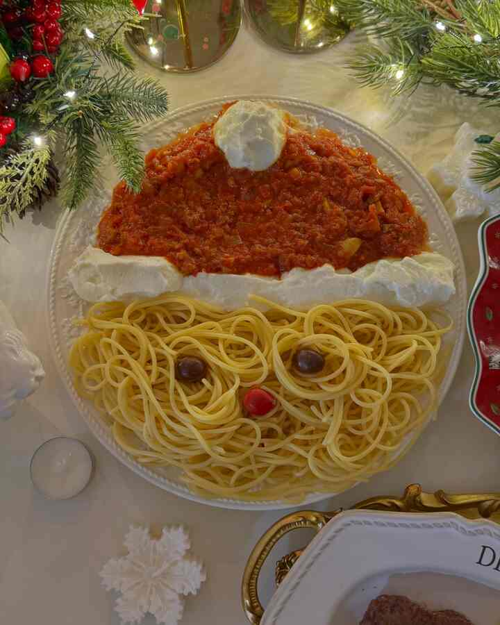 ホワイトとレッドのクリスマステーブルに、サンタの顔を形どったパスタの盛り付けが印象的なホームパーティーの料理