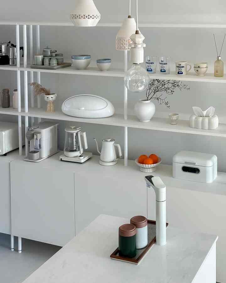 ソフトホワイト調のキッチン、多層の棚と整然としたキッチン用品が配置されたモダンなインテリア