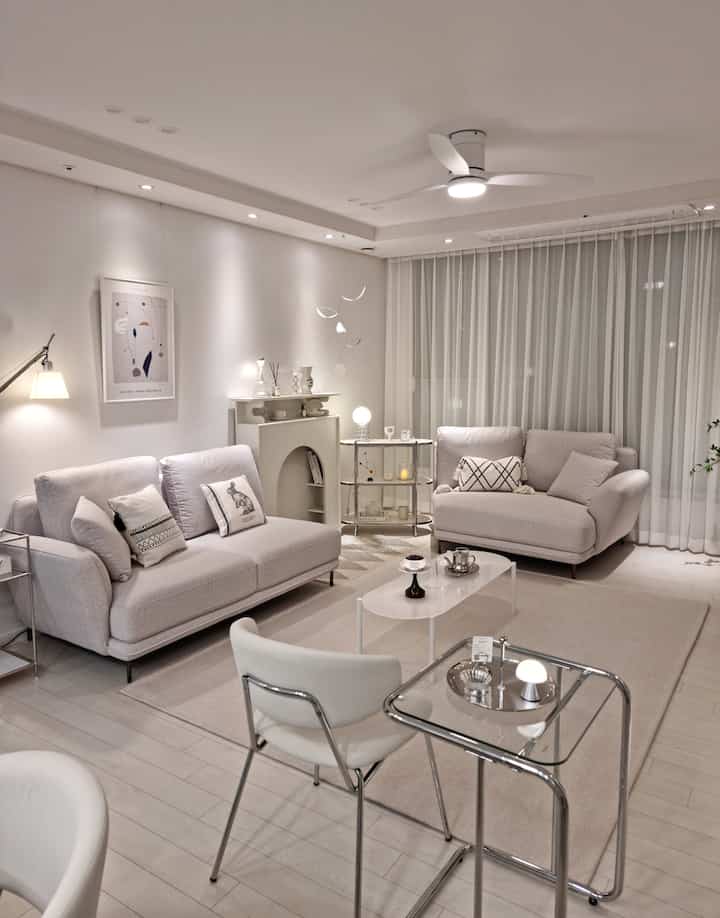 White-toned living room featuring fabric modular sofas and steel frame furniture with a modern ambiance