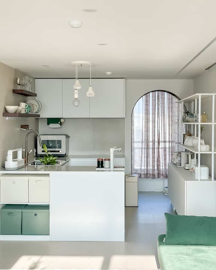白と緑の調和が美しいキッチンとリビングルーム、明るく清潔感のあるナチュラルモダンなインテリア