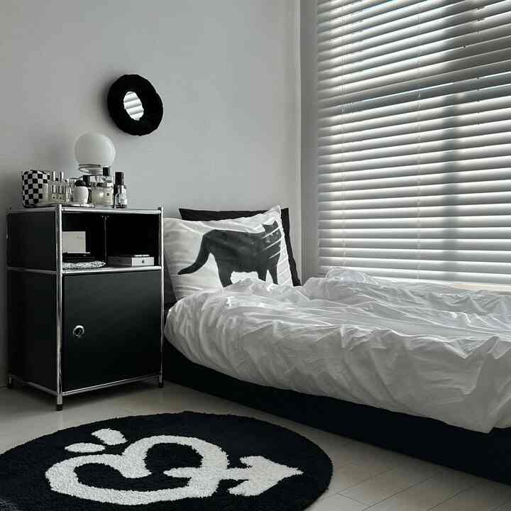 White and black bedroom space featuring cat print pillow and blinds with a modern interior