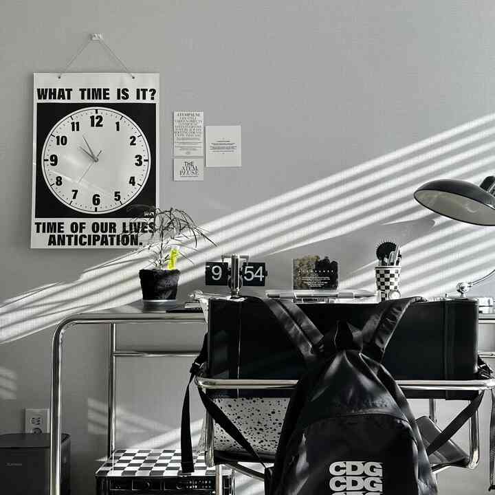 Black and white toned home office featuring a mid-century modern desk and armchair with a clean, modern atmosphere