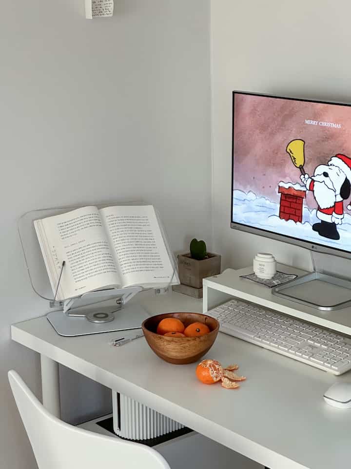 White and natural toned home office space, featuring a white desk with monitor and acacia wooden bowl creating a clean workstation