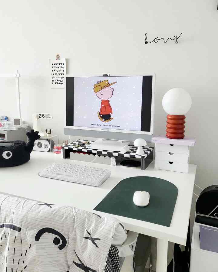 Monotone white home office space featuring a clean desk with monitor and keyboard, and a patterned chair in a modern workspace