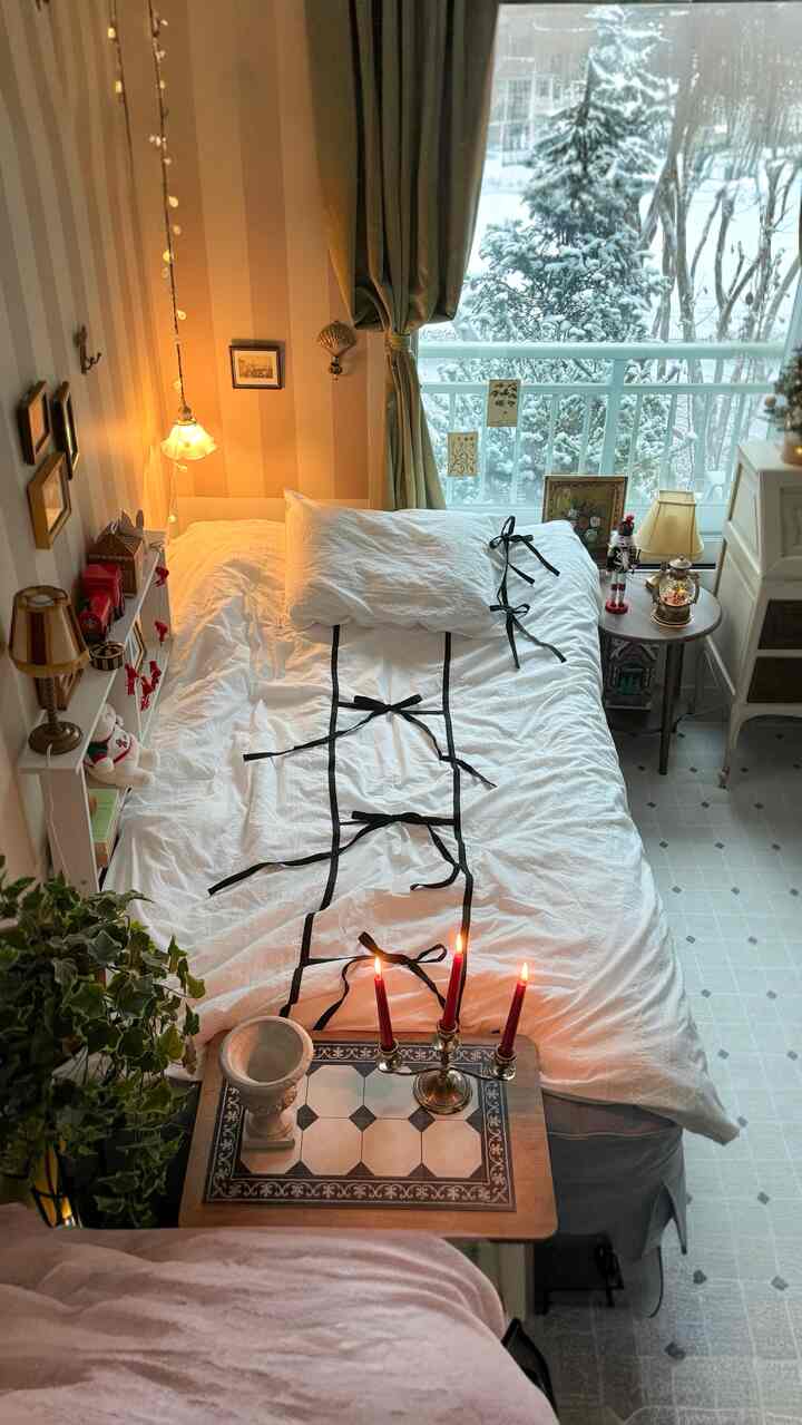 白と茶色のトーンの寝室、クラシックなヴィンテージホテル風のベッドリネンとキャンドルが配置された雰囲気のある空間