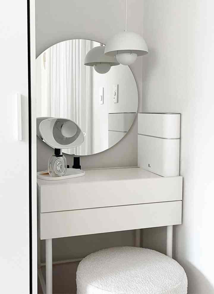 白を基調としたウォークインクローゼットの化粧台、丸い鏡とペンダントライトが配置されたシンプルな空間