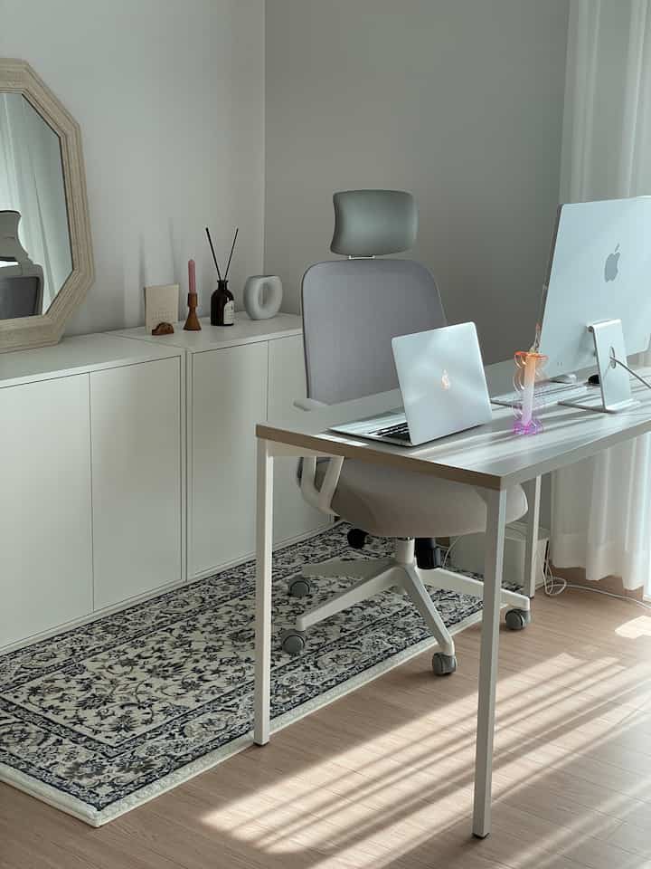 White and gray toned home office space featuring a simple desk and office chair with a clean, minimalist atmosphere