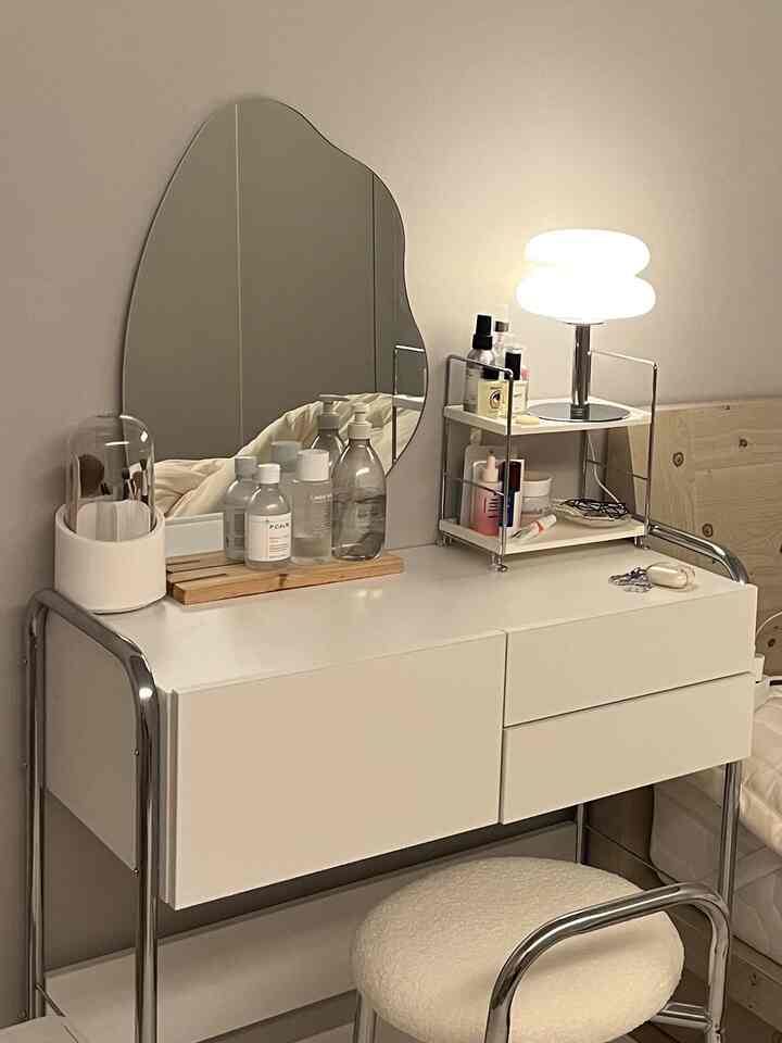 白とベージュの色調が調和した化粧台の空間、ムードランプと収納棚がすっきり配置されたシンプルな雰囲気のインテリア