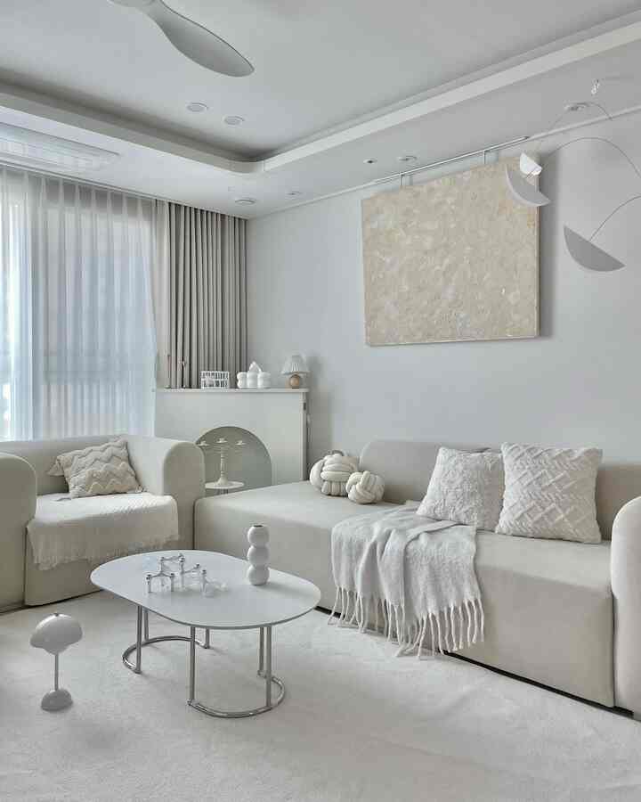 Bright white and beige toned living room featuring sofas and coffee table with a simple, natural interior design