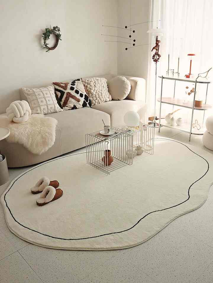 ホワイトとナチュラルトーンのリビング、雲の形のラグとベージュのソファが印象的な空間