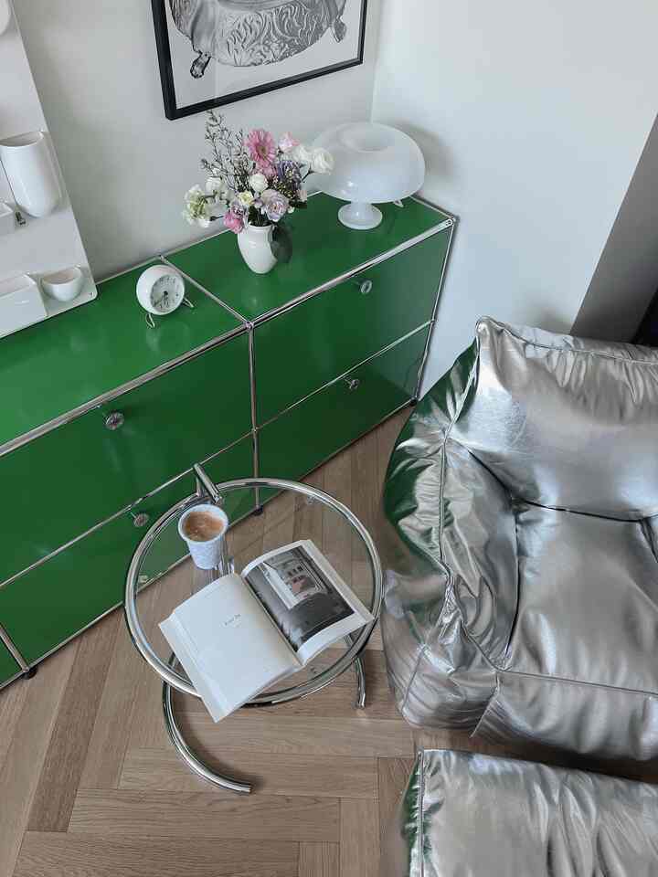 シルバーのビーズクッションと緑の収納キャビネットが配置されたモダンでナチュラルなリビングの一角