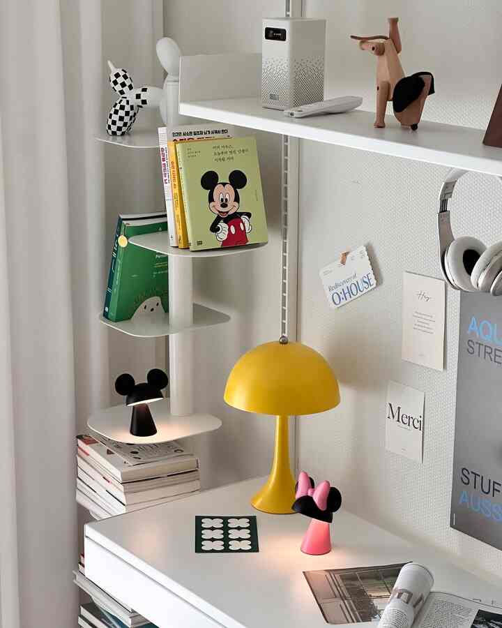 White and yellow Nordic style room featuring Mickey Mouse character table lamps and a neat bookshelf in a minimal space
