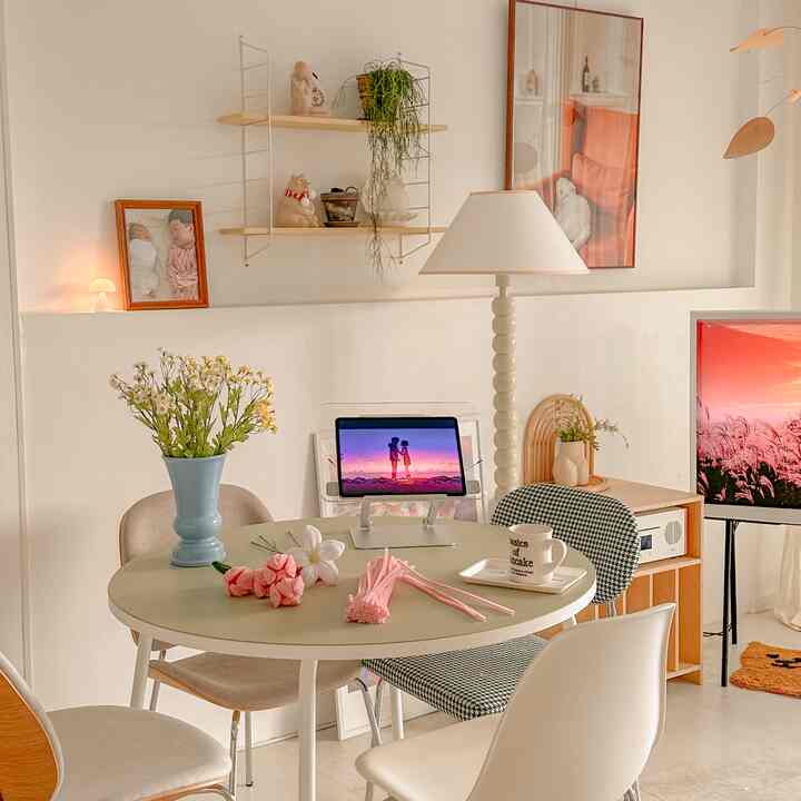A white and natural toned living dining area featuring a modern dining table, chairs, and ambient lighting creating a cozy atmosphere
