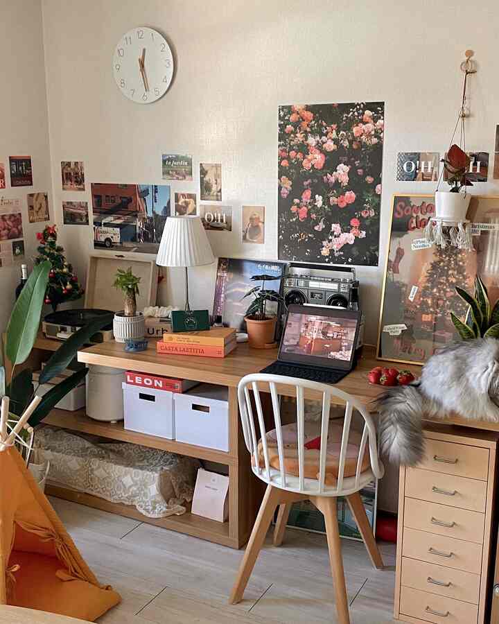 Natural wood tone and white home office desk space featuring a cat, plants, and warm cozy atmosphere