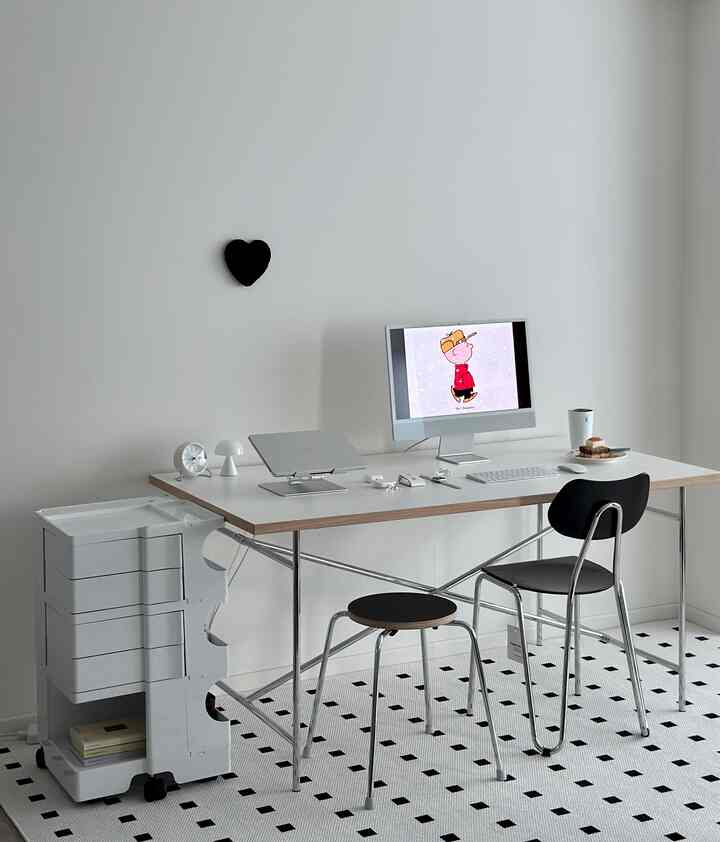 Monotone black and white home office featuring a clean desk and chair with a simple, minimalistic atmosphere
