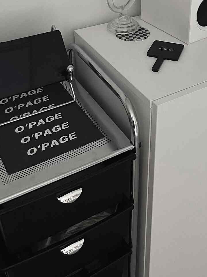 黒とシルバーのクロームフレームを用いたモダンなワンルーム空間、収納家具とオブジェが配置されたインテリア