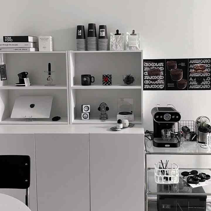 White-toned studio apartment featuring modern shelves and a coffee machine in a clean home cafe interior