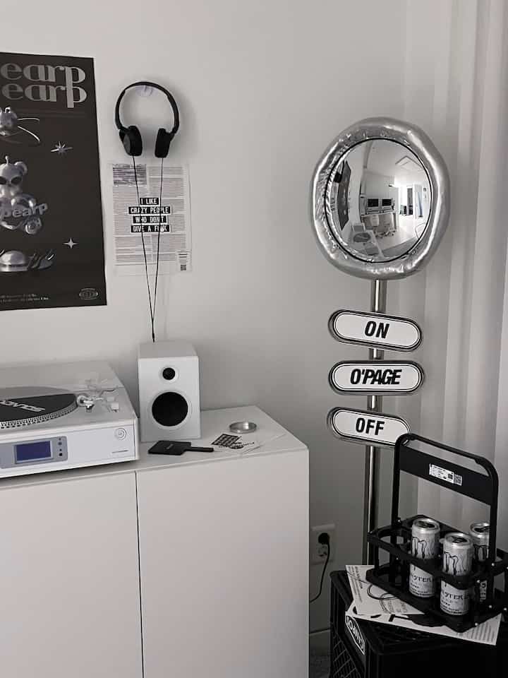 白い壁とキャビネットが背景のモダンなインテリア空間、シルバーの凸面鏡とオブジェが調和する洗練された雰囲気