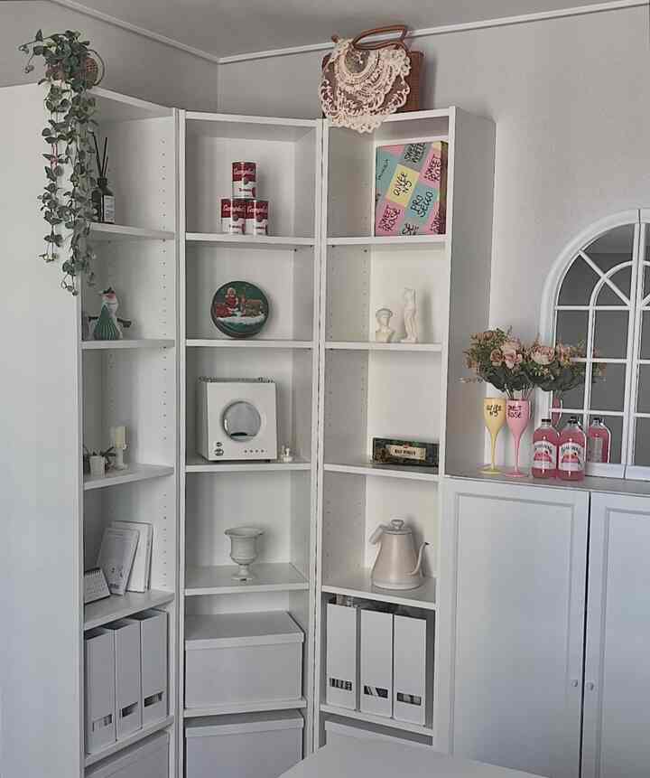 White-dominant corner storage cabinets with decorative objets creating a neat and vintage-inspired interior space