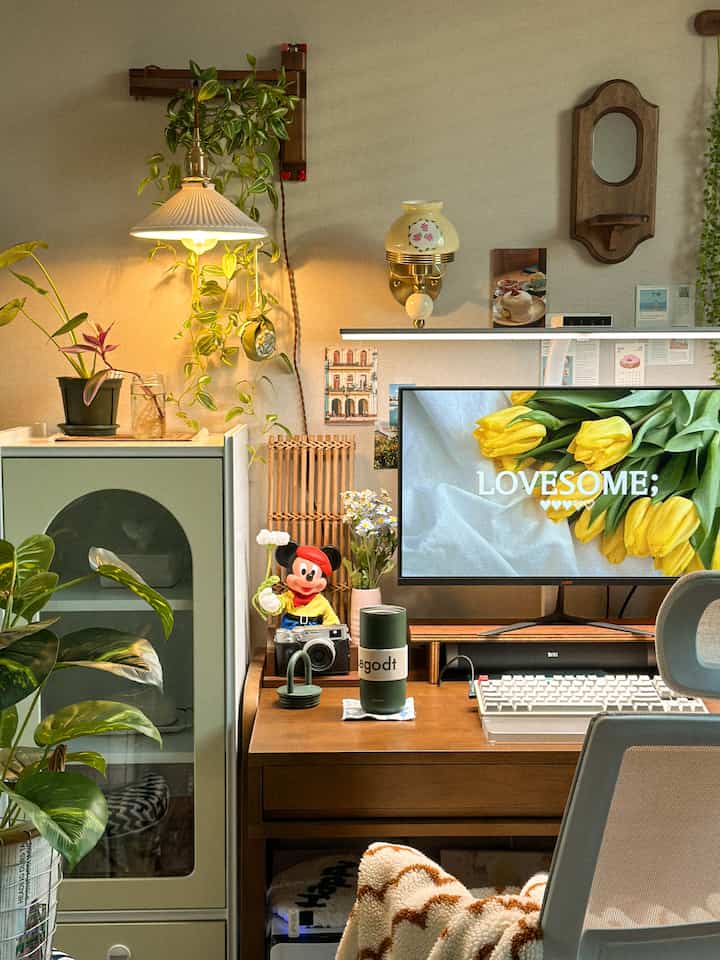 Natural-toned home office space featuring wooden desk, white lighting, and pet-friendly storage cabinet forming a cozy interior
