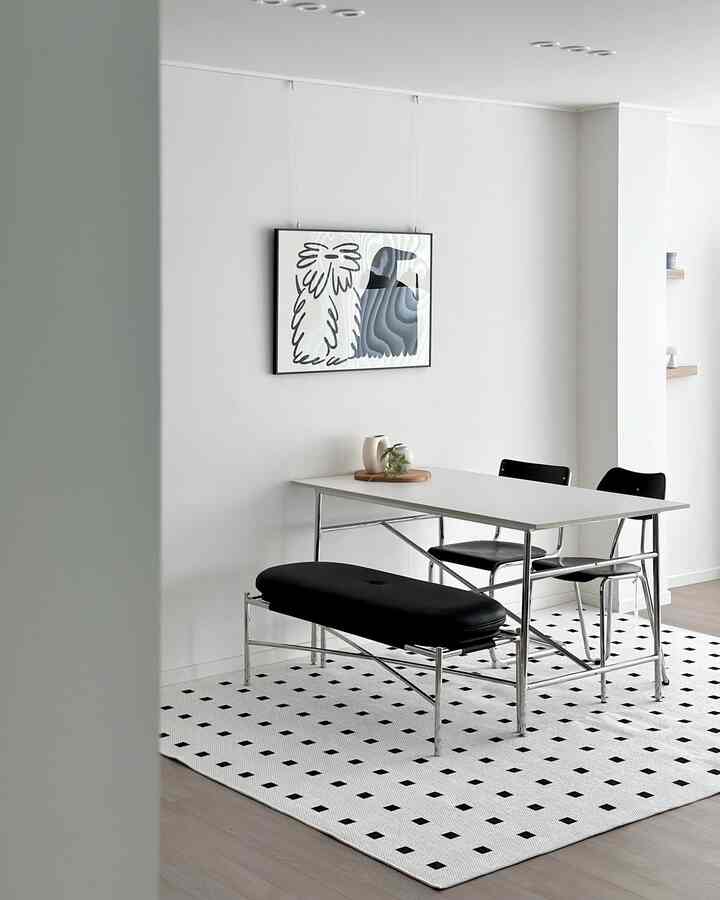 Black and white tone living room featuring ceramic table and bench with minimalist framed artwork creating a clean atmosphere