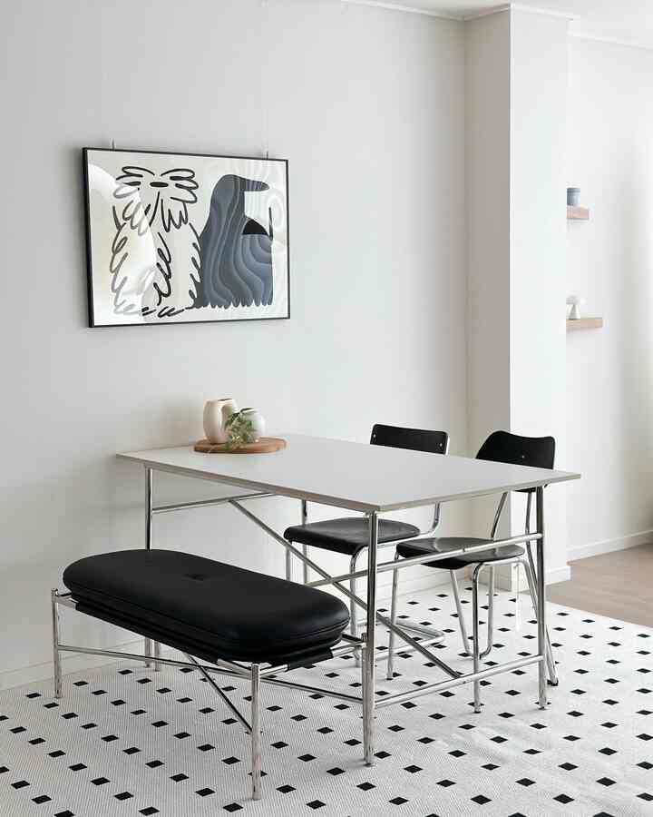 White and black toned living dining room featuring a ceramic table and chairs in a simple modern space