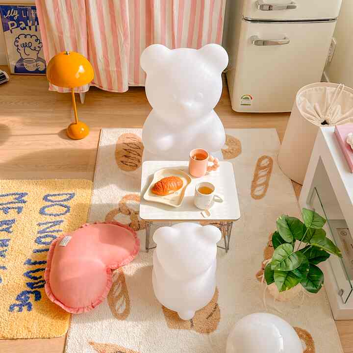 Pink and white toned kids' room featuring bear-shaped lighting and cozy decorative elements