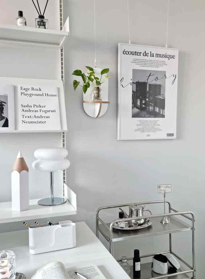 White and gray toned study space featuring mid-century modern desk and shelves with a metal trolley, creating a clean modern atmosphere