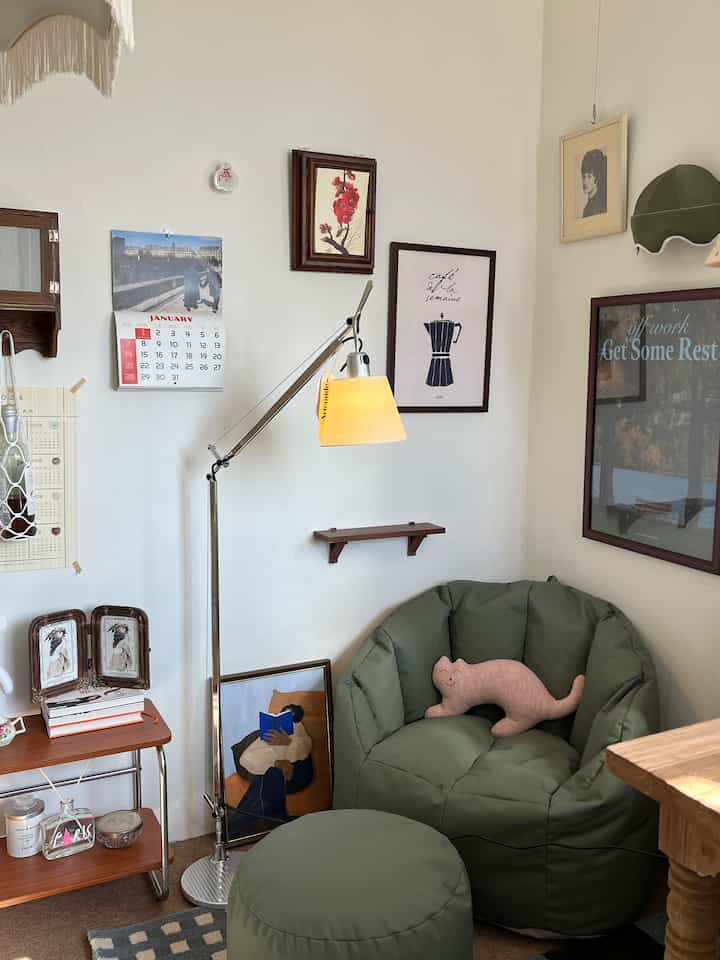 Natural-tone vintage-style living room corner featuring dark green bean bag and floor lamp in a cozy atmosphere