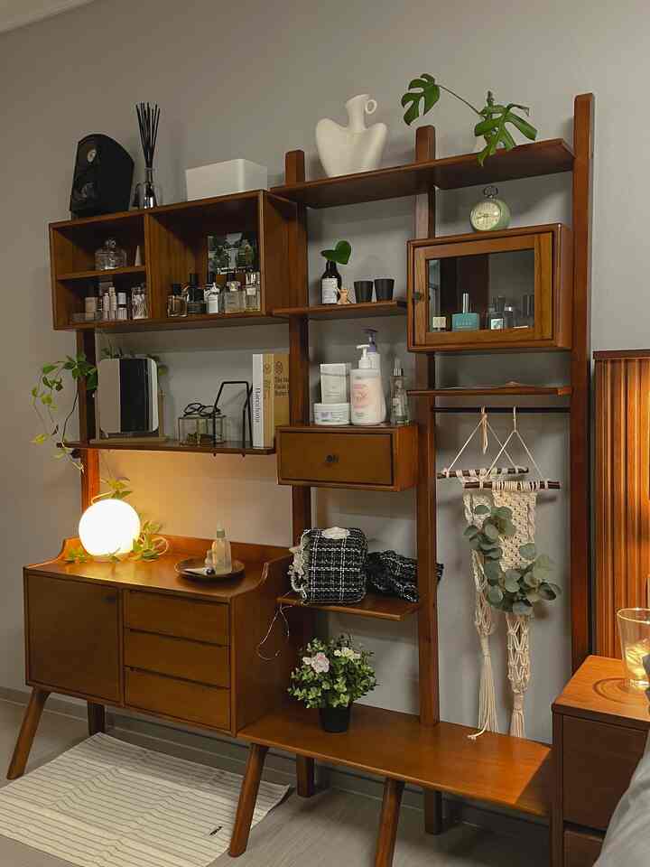 ブラウンの木目調キャビネットと化粧台が配置された、居心地の良いナチュラルな寝室の収納スペース