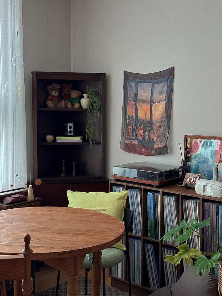 ウッドトーンのヴィンテージ調スタジオアパートメントのリビング、木製家具と植物が配置された雰囲気のあるインテリア