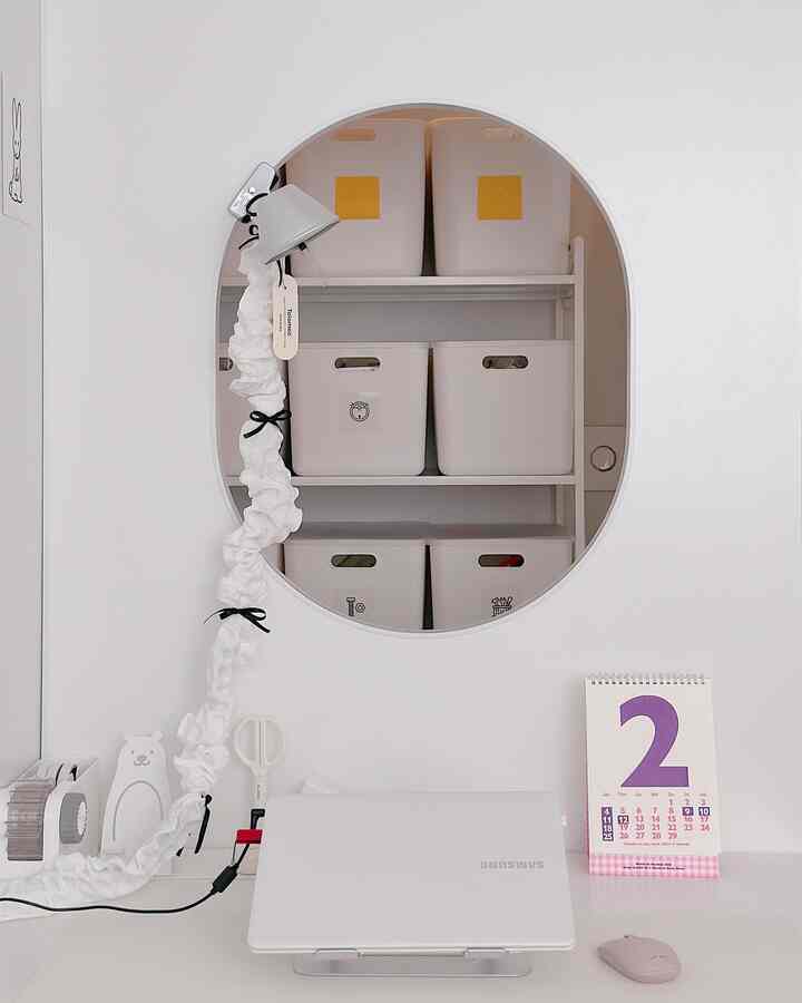 White-toned home office space featuring neat storage ideas and a simple desk setup