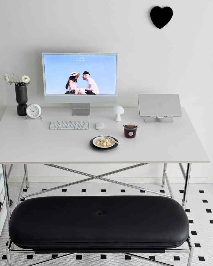 White and black toned living room home office featuring a sleek desk and rug with a modern atmosphere