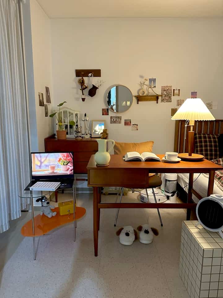 Beige and natural-toned bedroom featuring wooden desk and lamp creating a cozy home office atmosphere