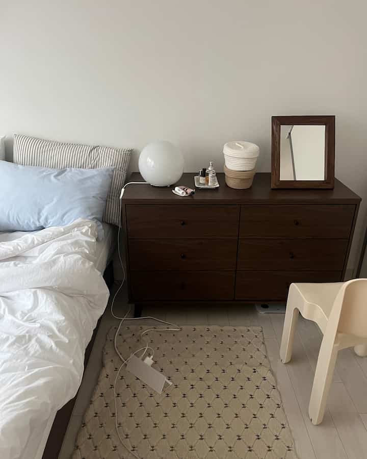 White and brown toned bedroom featuring bed and dresser arranged to create a cozy atmosphere