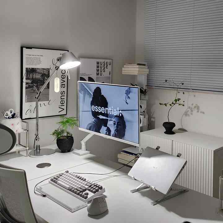 白とグレーの色調の書斎、モニターとデスクランプが配された印象的なホームオフィス