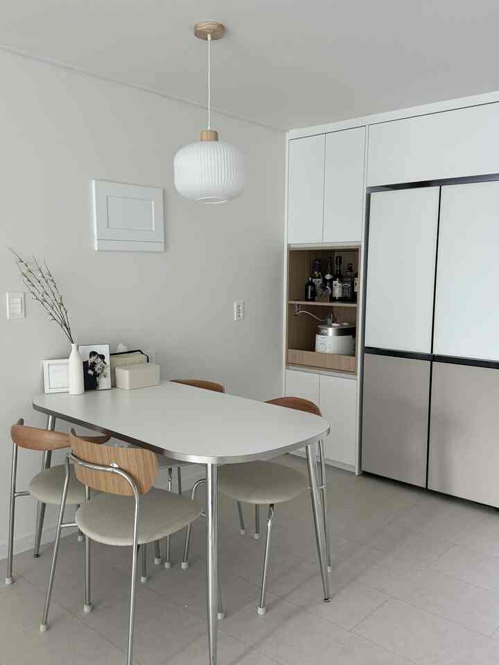 白と木目調が調和するキッチンダイニングスペースで、シンプルかつ自然な雰囲気のあるインテリア