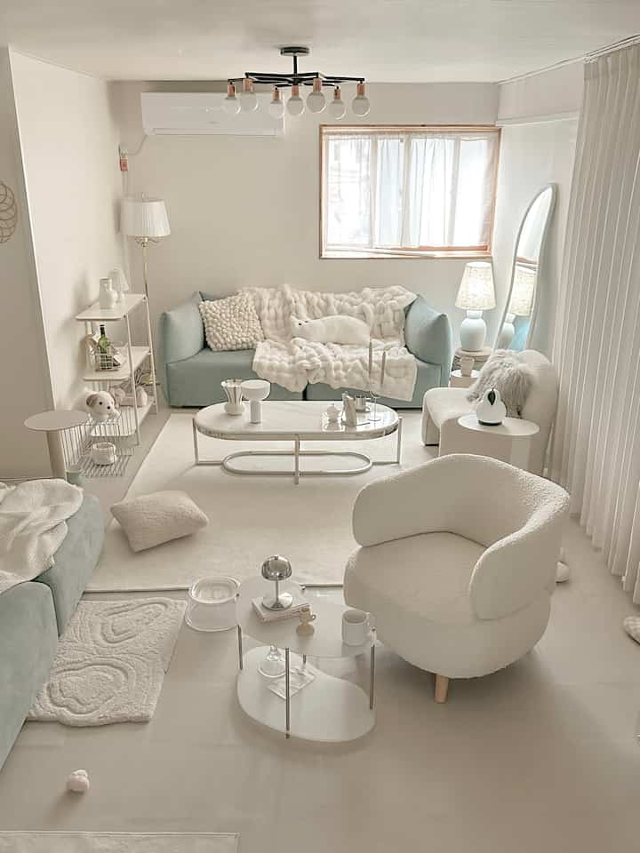 White and silver toned living room featuring Mid-Century Modern sofa and marble-look coffee table in a cozy setting